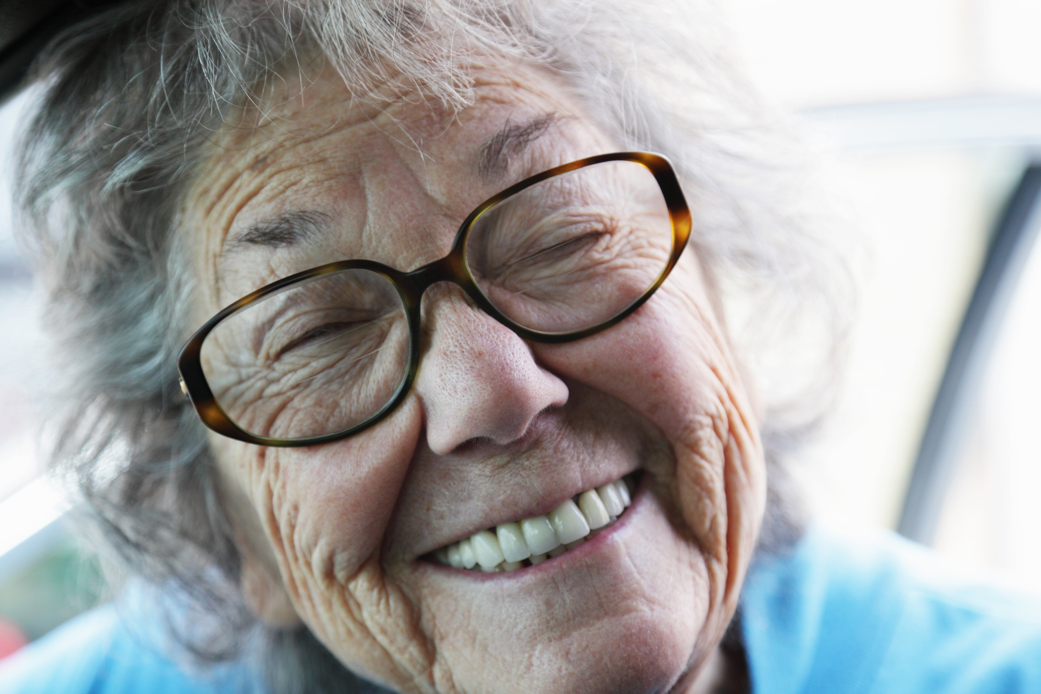 a elderly woman with dentures smiling.
